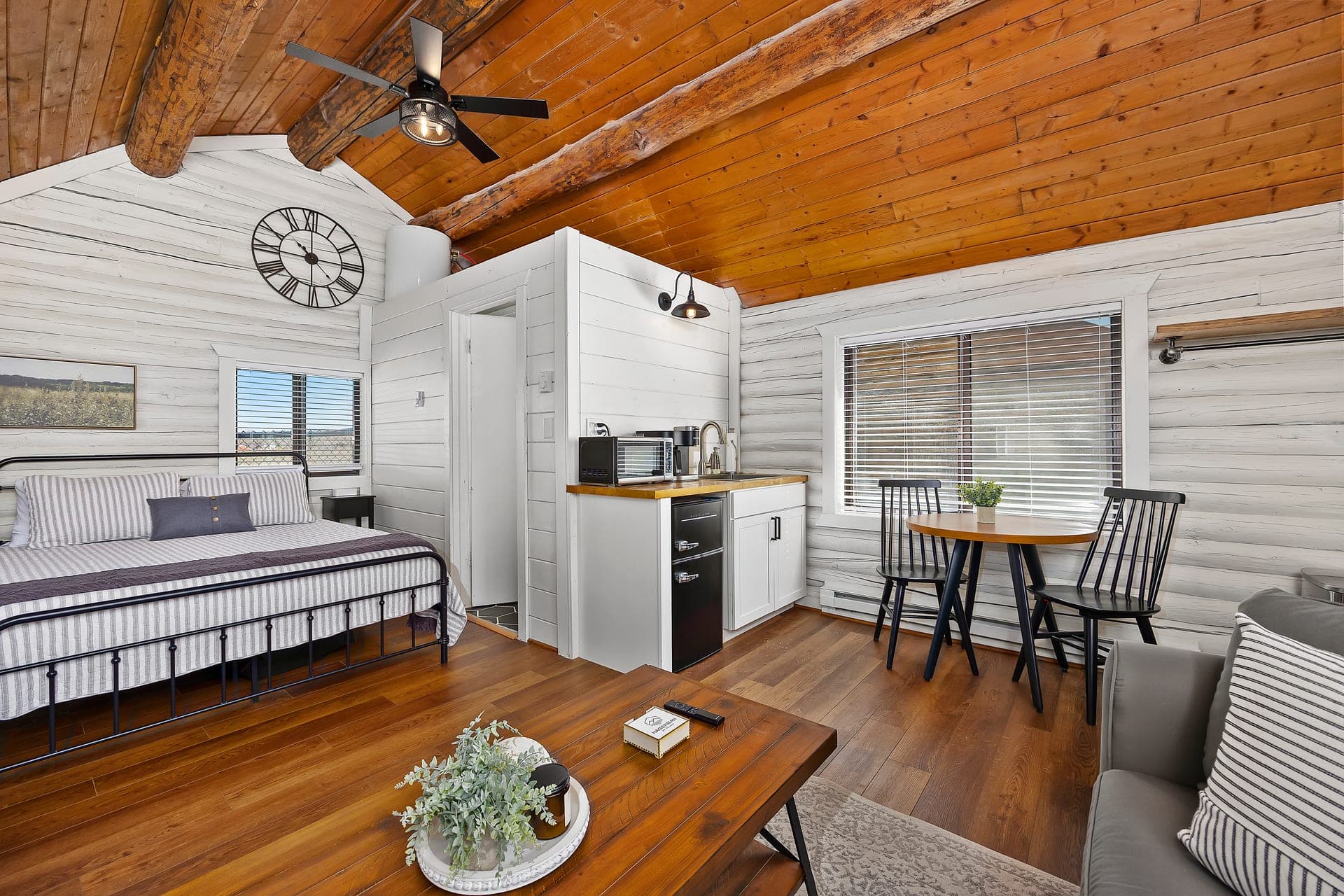 Inside the Mineral Springs cabin: cedar ceiling, log beams, bed, kitchenette, and dining nook